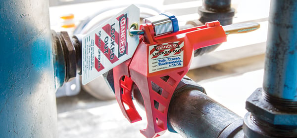 LOTO lock and tag affixed to a lockout-tagout device attached to a pipe valve