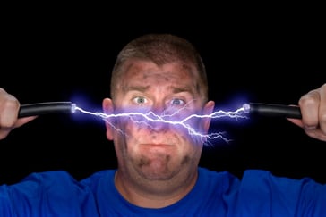 man holding electrified cable that is split in the middle with electricity arcing out of it