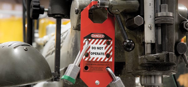 group LOTO lockout-tagout tag with 2 locks affixed to a machine